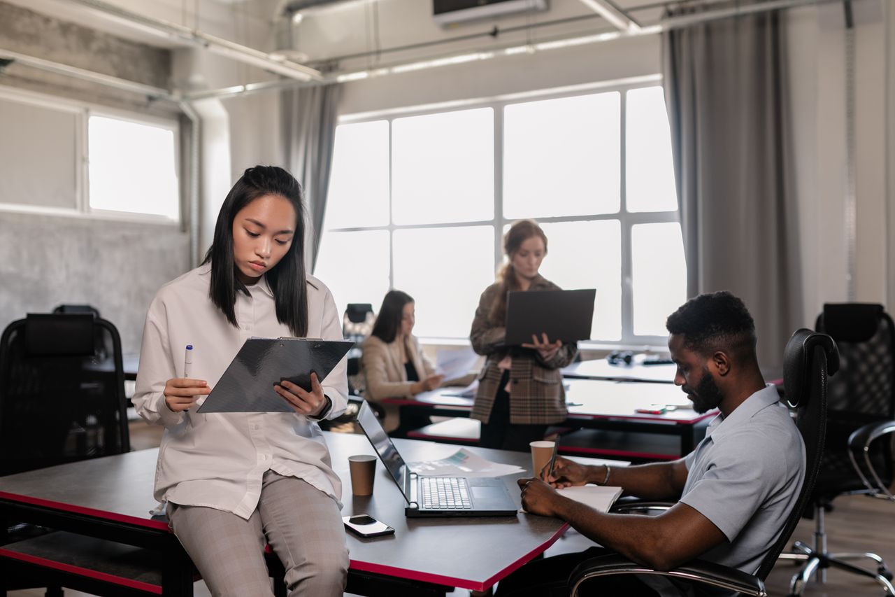 Diverse office colleagues working together with laptops in a stylish modern space.